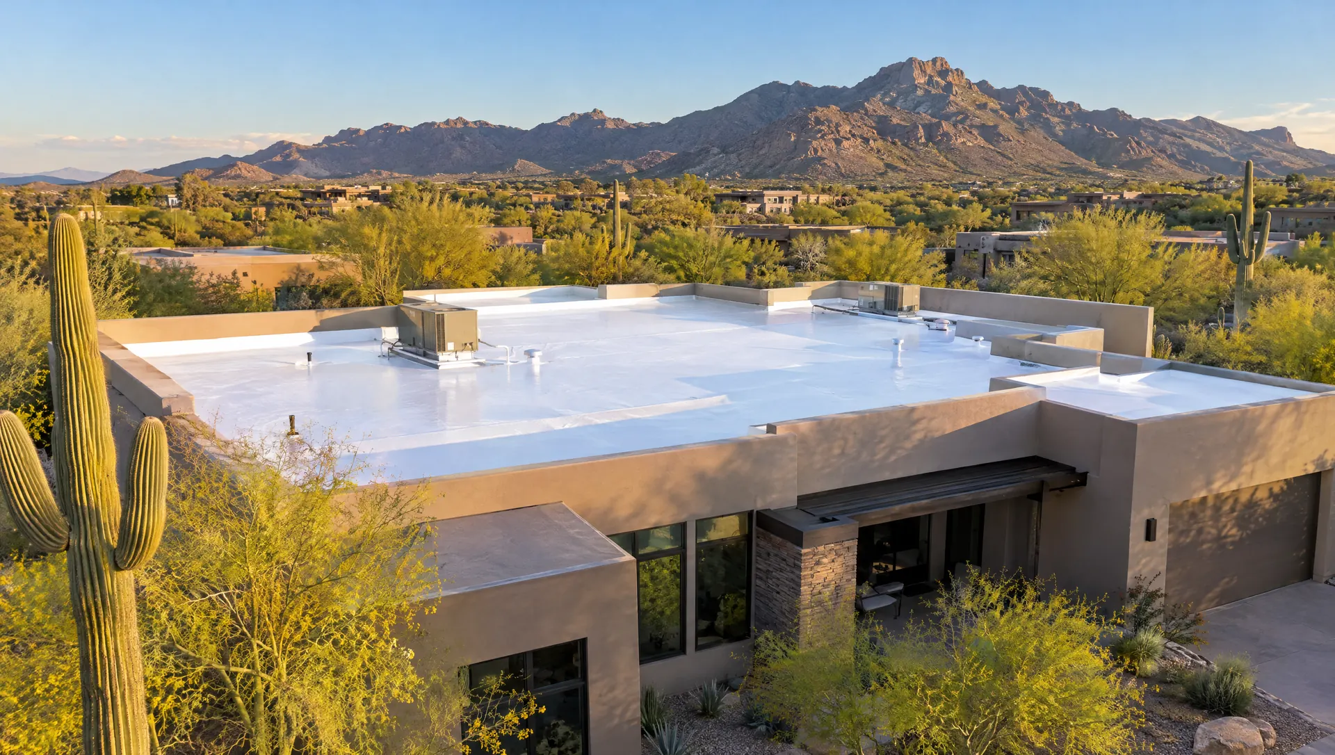 Desert-modern Scottsdale home with a bright white coated flat foam roof, saguaros and the McDowell Mountains behind