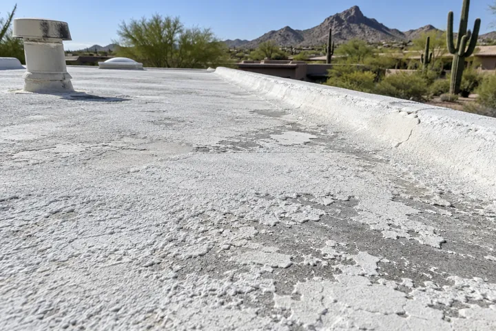 Close view of chalky, worn coating on an older foam roof