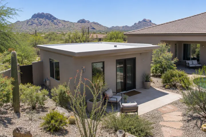 Small flat foam roof on a detached casita beside a desert home