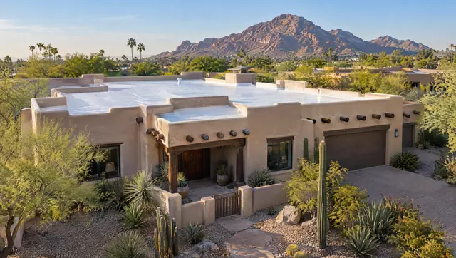 Pueblo Revival stucco home in Scottsdale with a new white-coated flat foam roof behind its parapets